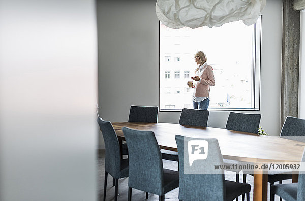 Businesswoman in conference room looking out of window
