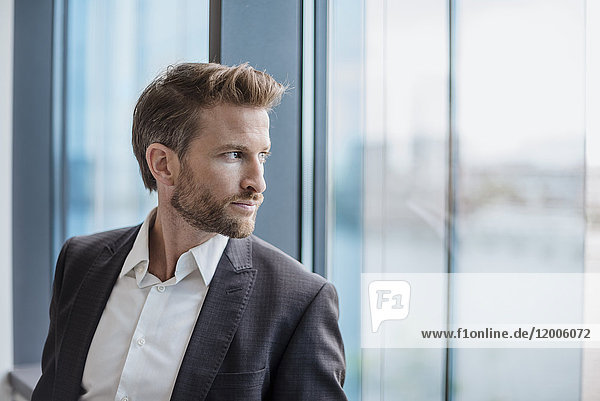 Portrait of businessman looking out of the window
