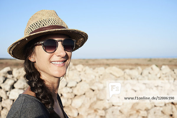 Spanien  Menorca  Portrait der lächelnden Frau mit Strohhut und Sonnenbrille