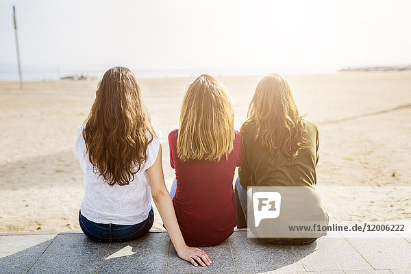 Rückansicht von drei Freundinnen am Strand