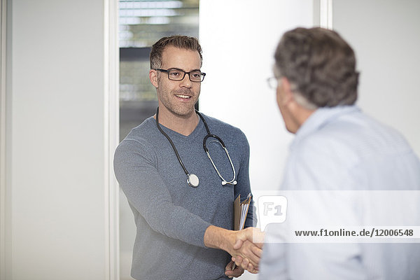 Doctor shaking hands with patient in medical practice