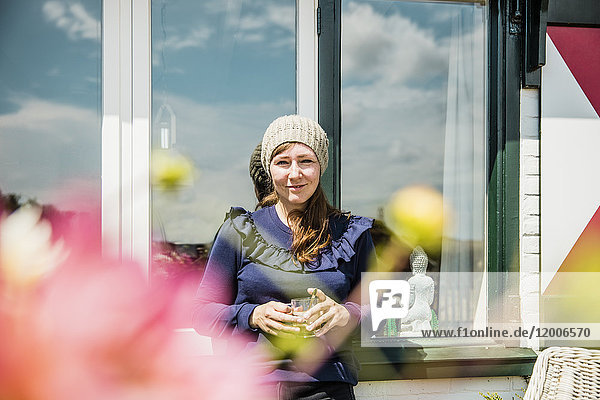 Portrait of smiling woman at a window
