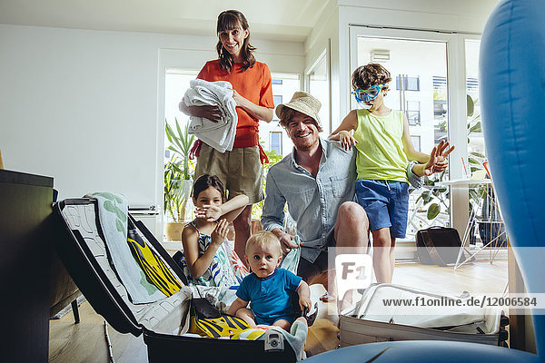 Happy family of five packing for holiday trip