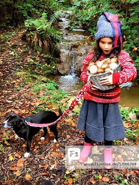 Erstauntes junges Mädchen hält Korb mit magischen Pilzen