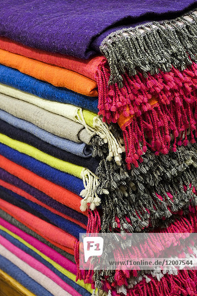 Piles of multicolor blankets with fringe