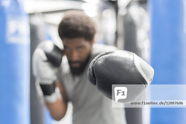 Portrait of Black man wearing boxing gloves in gymnasium