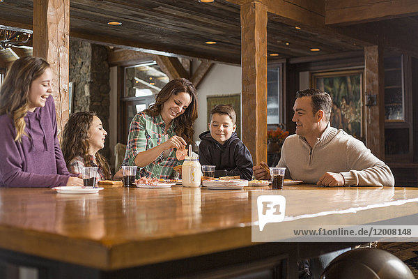 Lächelnde kaukasische Familie beim Essen am Tisch