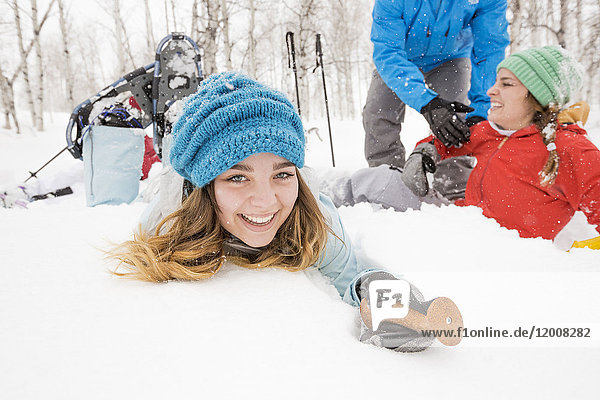 Porträt eines lächelnden kaukasischen Mädchens  das in den Schnee fällt