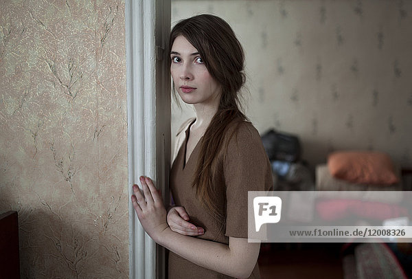 Serious Caucasian woman leaning in doorway