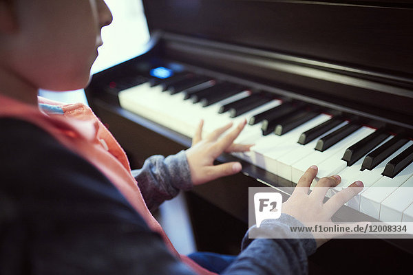 Hispanischer Junge spielt Klavier