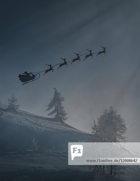 Silhouette des Weihnachtsmanns und Rentiere fliegen Schlitten im Winter