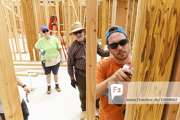 Volunteer using drill at construction site