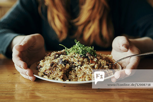 Hands of woman holding a plate of rice