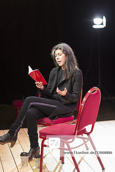 Hispanic woman reading script on theater stage