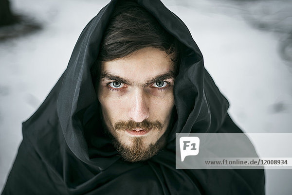 Kaukasischer Mann mit Bart trägt Gewand im Winter