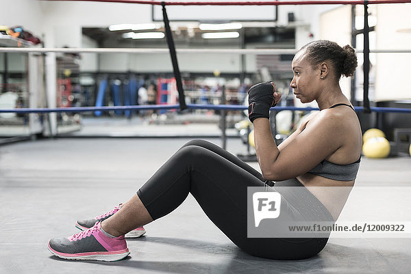 Black woman sitting on floor in boxing ring