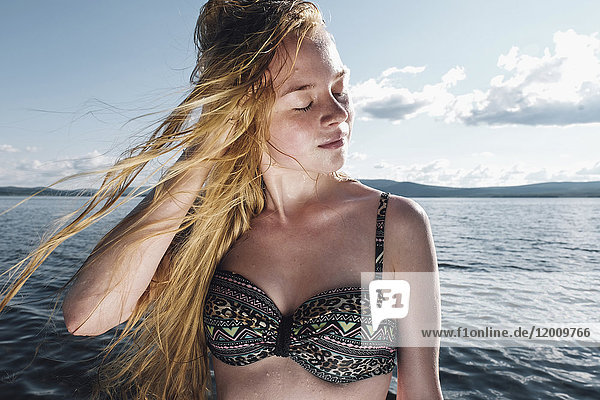 Wind weht Haare der kaukasischen Teenager-Mädchen im Meer