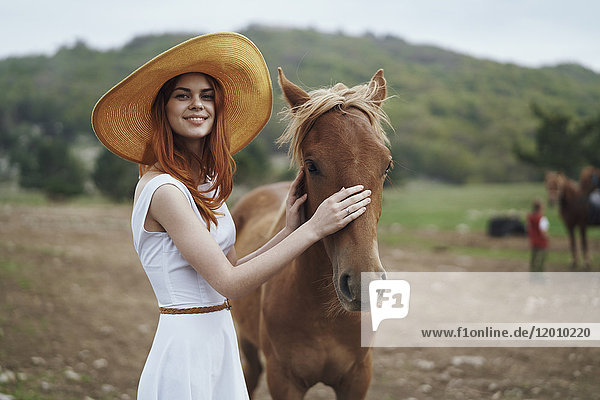 Lächelnde Frau streichelt Pferd