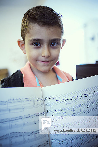 Hispanic boy showing sheet music