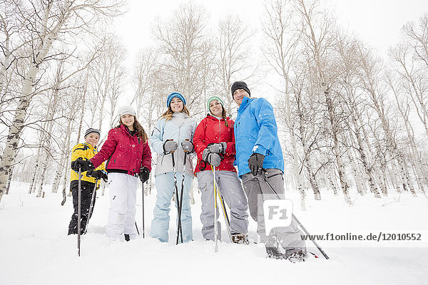 Porträt einer lächelnden kaukasischen Familie beim Schneeschuhwandern