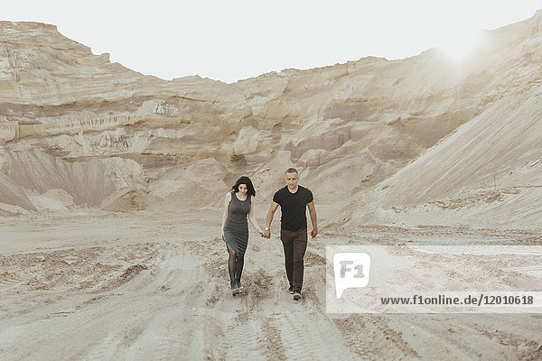 Paar aus dem Nahen Osten geht in der Wüste spazieren