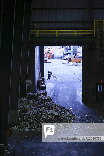 Man sweeping garbage with broom
