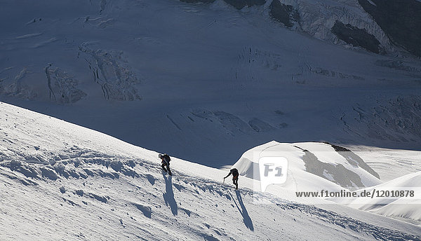 Kaukasische Männer beim Wandern auf einem Berg im Winter