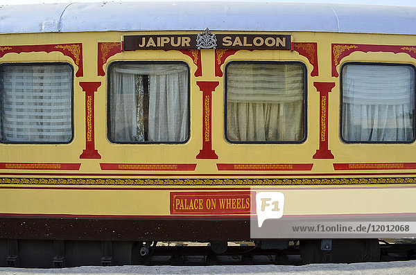 Zugwaggons in den Farben Rot und Gelb  auf einem Bahnhof in Rajasthan. Der Palast auf Rädern.