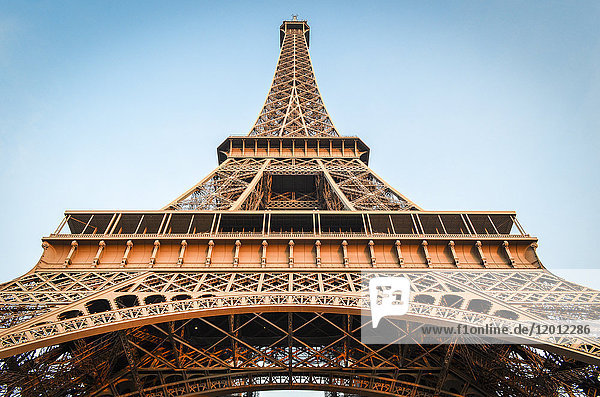 Tiefblick auf den Eiffelturm in Paris  Champs de Mars vor blauem Himmel.