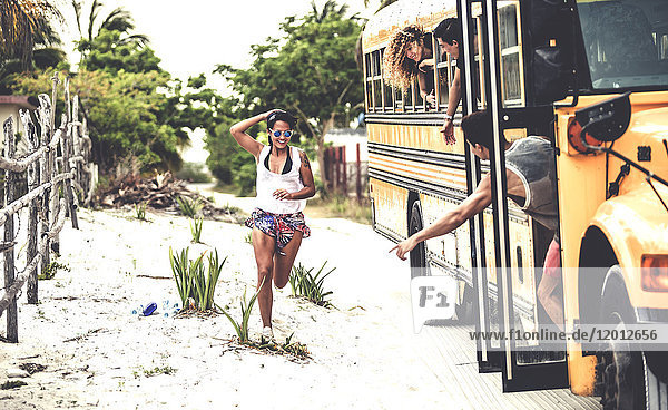 A young woman chasing after a moving school bus.