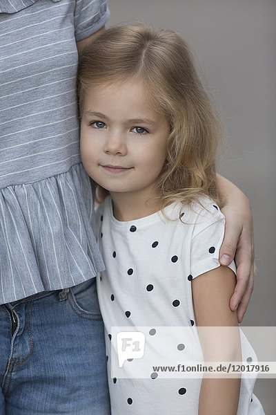 Porträt eines süßen Mädchens  das auf grauem Hintergrund steht.