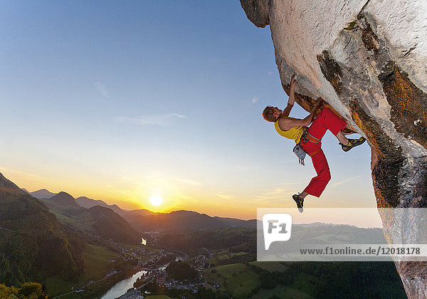 Freeclimber hängt an Felsen  Sonnenuntergang