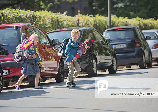 Zwei Kinder mit Schultüte laufen über Straße
