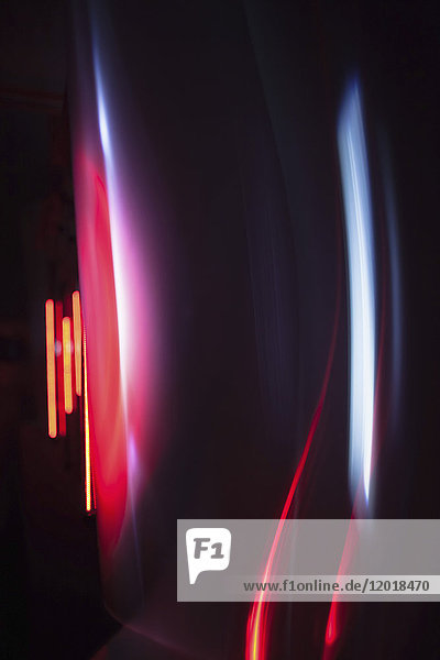 Abstract image of red and gray light trails over black background