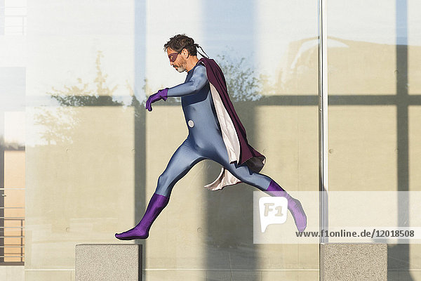 Superheld springt auf Beton gegen Glaswand