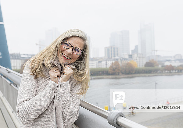 Blonde Frau steht auf einer Brücke in Frankfurt
