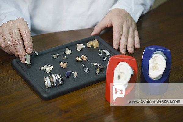 Mittelteil des Hörgeräteakustikers verschiedene Hörgeräte am Tisch in der Arztpraxis