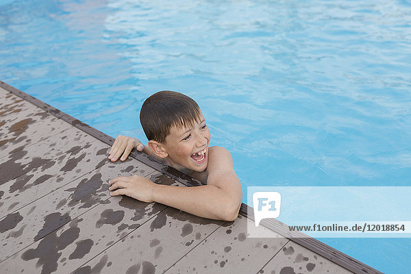 Hochwinkelansicht eines fröhlichen  hemdlosen Jungen im Schwimmbad