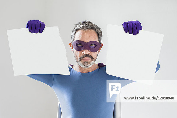 Porträt eines Superhelden mit gerissenem leeren Plakat auf weißem Hintergrund