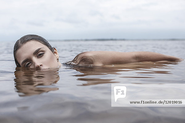 Porträt einer jungen Frau  die im See schwimmt