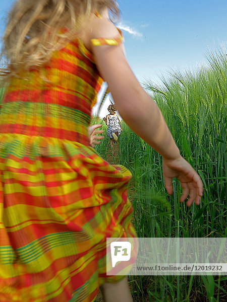 kleines Mädchen läuft in einem Getreidefeld