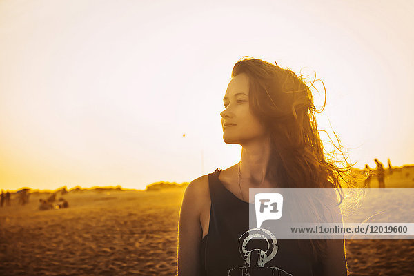 Porträt einer jungen Frau im Profil  am Strand Praia do Barril in einem Sonnenuntergang  Stadt deTavira  Region Algarve  Portugal