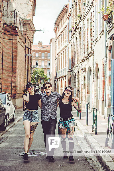 Three young people walking in the street  cityscape