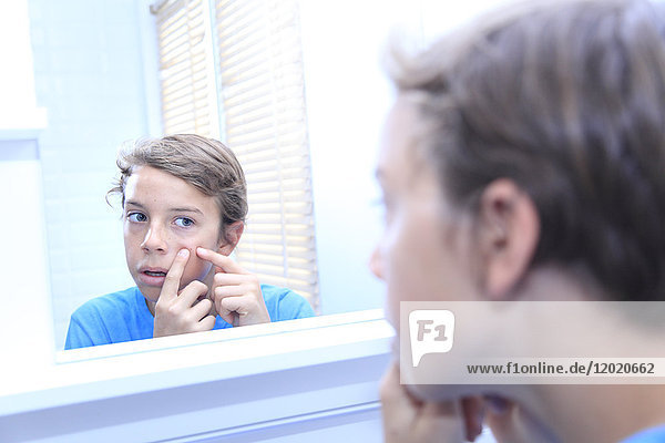 Frankreich,  kleiner Junge im Badezimmer,  der in den Spiegel schaut.