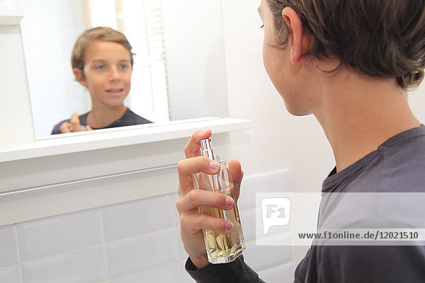 France  teenager in his bathroom using parfum.