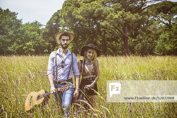 Porträt eines jungen Paares Hipster Fahrt in das Land  hält in der einen Hand eine Gitarre die andere