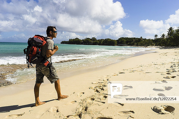 Ein Mann geht allein am Strand von Moustique spazieren  Saint-Louis  Marie-Galante  Guadeloupe  Frankreich