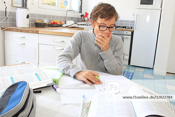 Frankreich  müder Teenager  der zu Hause an seinen Lektionen arbeitet.