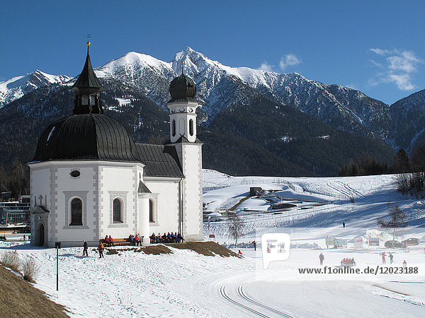 Austria  North Tirol  Seefeld  the Seekirchl chapel on the cross-country skiing station of Seefeld in the background the snow-capped mountains of the Karwendel