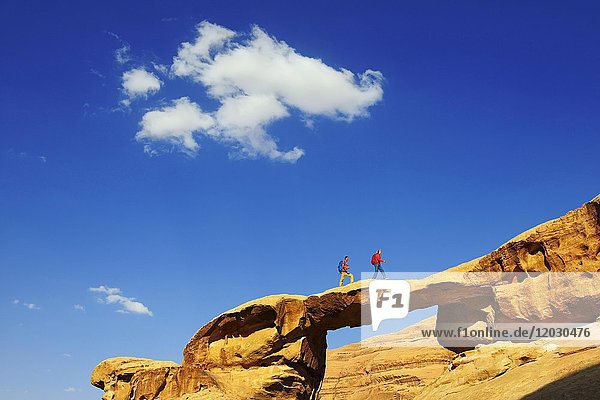 Couple hiking at Rock-Arch Um Alfrooth  Wadi Rum  Jordan  Asia